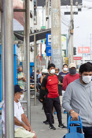 Lima, Peru - April 8, 2020: Men in line doing social distancing practices in the middle of a coronavirus outbreak in South America. Men's day only, gender-based quarantine, men lined up to buy groceries.のeditorial素材