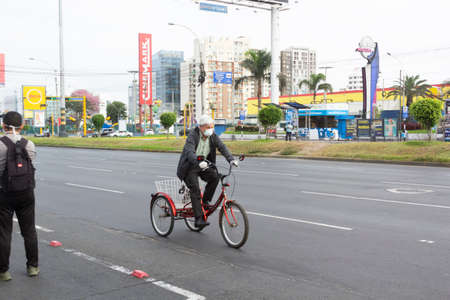Lima, Peru - April 8, 2020: Man with a bicycle mask in the middle of a coronavirus outbreak in South America. Buying food in times of pandemic.のeditorial素材