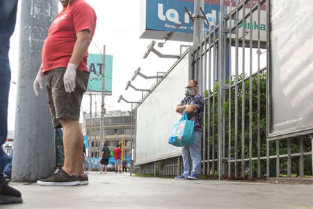Lima, Peru - April 8, 2020: Men in line doing social distancing practices in the middle of a coronavirus outbreak in South America. Men's day only, gender-based quarantine, men lined up to buy groceries.のeditorial素材