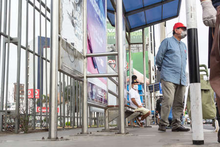 Lima, Peru - April 8, 2020: Men in line doing social distancing practices in the middle of a coronavirus outbreak in South America. Men's day only, gender-based quarantine, men lined up to buy groceries.のeditorial素材