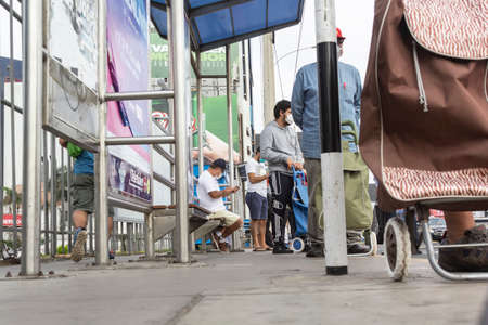Lima, Peru - April 8, 2020: Men in line doing social distancing practices in the middle of a coronavirus outbreak in South America. Men's day only, gender-based quarantine, men lined up to buy groceries.のeditorial素材