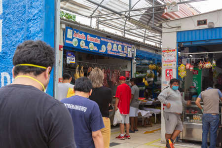 Lima, Peru - April 8, 2020: Men in line doing social distancing practices in the middle of a coronavirus outbreak in South America. Men's day only, gender-based quarantine, men lined up to buy groceries.のeditorial素材