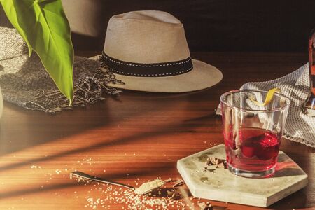 Rum bottle, glasses and oranges, hat on wooden table, selective focus, notebook and glasses on office desk.の写真素材