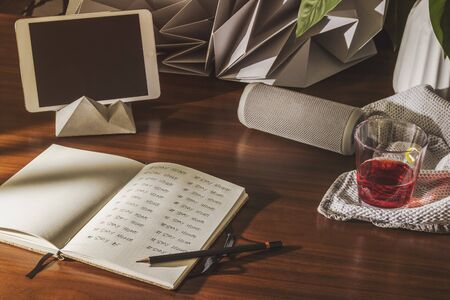 Rum bottle, glasses and oranges, hat on wooden table, selective focus, notebook and glasses on office desk.の写真素材