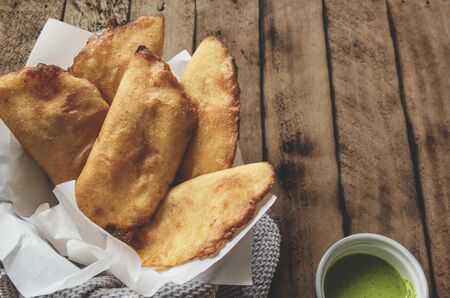 VENEZUELAN COLOMBIAN FOOD. Venezuelan typicals corn empanadas with meat in clay bowl with avocado sauce, Fried empanadas, stuffed with chicken and meat, Typical breakfast in Latin American countries, top view.の写真素材