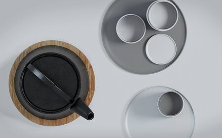 Modern black cast iron teapot and tea cups and a minimalist table white. Top view, set for tea time. 3d rendering.の写真素材