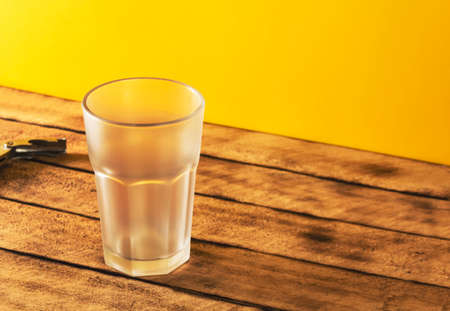 Empty beer glass, bottle beer on a wooden background and yellow, selective focus.の写真素材