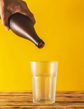 Empty beer glass, bottle beer on a wooden background and yellow, selective focus.の写真素材