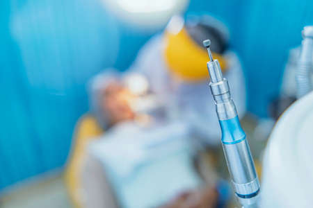 Dental tools and equipment, close-up dental instruments, Cute woman sits in dentist chair while dentist examine her teeths. Selective focus.の写真素材