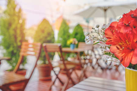 romantic coffee shop, Cozy street with flowers and French-style cafe table. Empty cafe terrace with white table and chair. Pink exterior of the cafe restaurant. interior Street cafe.の写真素材