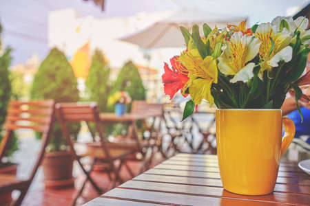 romantic coffee shop, Cozy street with flowers and French-style cafe table. Empty cafe terrace with white table and chair. Pink exterior of the cafe restaurant. interior Street cafe.
