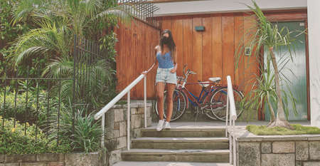 Young woman with protective mask leaving home to ride a bike on sunny summer day, AncÃ³n - Peru...