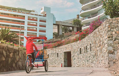 Taxy bike - Tricycle taxi on the boulevard by the pier in Ancon, Peru, sunny day. New normal concept