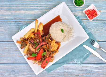 Peruvian food "lomo saltado": A salted beef with tomatoes, onion, fried potatoes and rice. top viewの写真素材