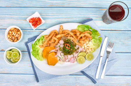 Peruvian food: fish ceviche and chicharron de pez with fried cassava, sweet corn and sweet potato, served on a white plate, Traditional Peruvian ceviche accompanied by fish, corn pancake, sweet potato, canchita and plenty of spicy juice. Fish ceviche and chicharronの写真素材
