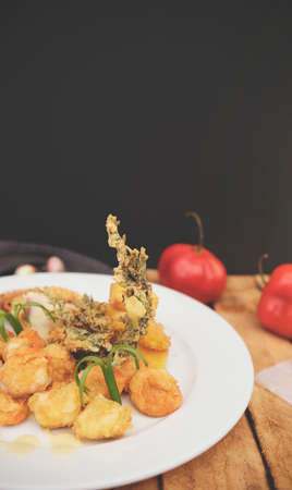 Peruvian food: Sauteed Shrimp with Herbs and Garlic, wooden table, served on a white plate,...