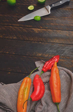 Peruvian peppers with other ingredients on wooden table and knife (limo pepper, ecabeche pepper and lemon)) top view. Selective focusの写真素材