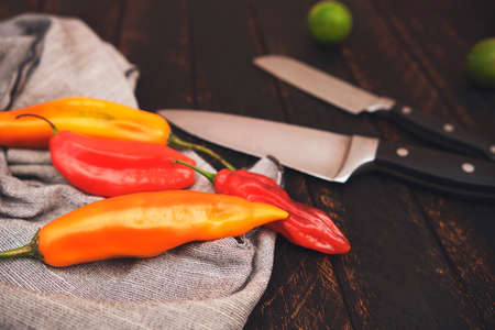 Peruvian peppers with other ingredients on wooden table and knife (limo pepper, ecabeche pepper and lemon)) top view. Selective focusの写真素材