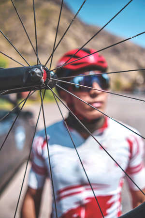 Portrait of young cyclist with his bike on the road. Sport concept, Selective focusの写真素材