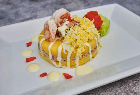 Peruvian Food: Causa stuffed with tuna. Tuna causa stuffed. Traditional peruvian dish from yellow potato, tuna, avocado on white plate. Selective focusの写真素材