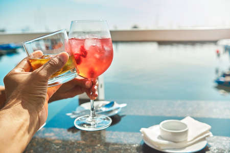 Couple toasting the beginning of summer at marina, cheers cups and glass, summer concept.の写真素材