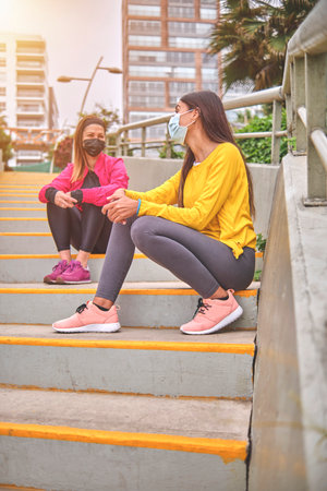 Portrait of two young beautiful sport woman resting after workout in the city, Sport lifestyle conceptの写真素材