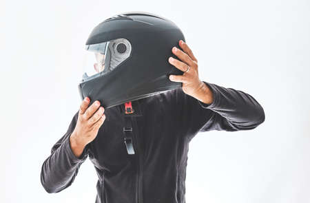 Man with a motorcycle helmet giving a thumbs up gesture. Isolated on white studio wall.