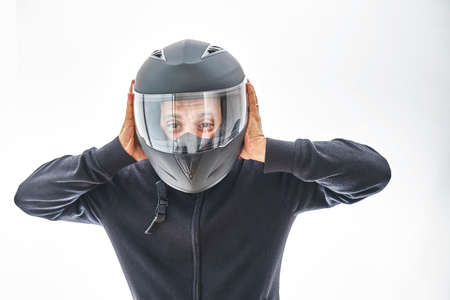 Man with a motorcycle helmet giving a thumbs up gesture. Isolated on white studio wall.の写真素材
