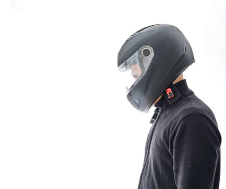 Portrait of guy with black checkered jacket and motorcycle helmet pretending to ride motorcycle, isolated on white studio wall.の写真素材