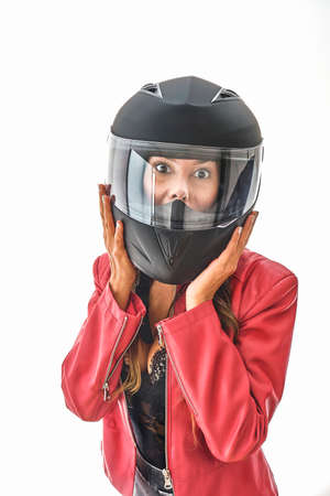 Beautiful young woman smiling in protective motorcycle helmet in studio, Power woman concept.の写真素材
