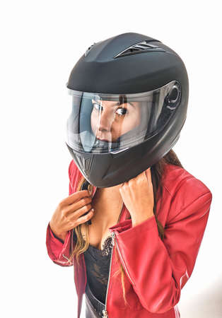 Beautiful young woman smiling in protective motorcycle helmet in studio. Power woman conceptの写真素材