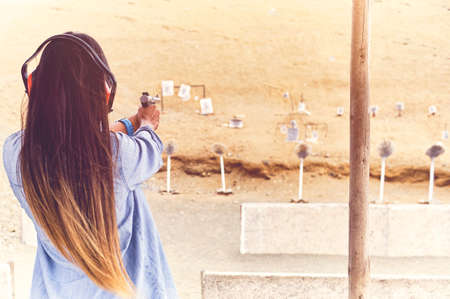 Woman releasing stress, Instructor helping woman with gunの写真素材