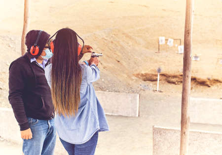 Woman releasing stress, Instructor helping woman with gunの写真素材