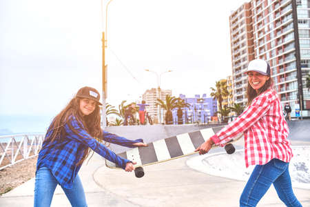 Angry girls fighting for a skateboard in skate park. friends doing wrestling parody.の写真素材