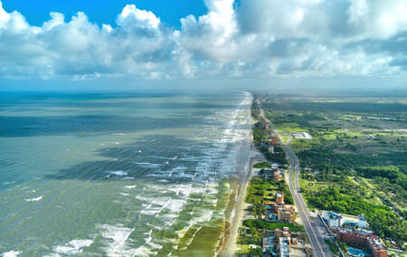 Beautiful Caribbean road with palm trees along the coast of Venezuela, Tucacas hotel zone, aerial view.の写真素材