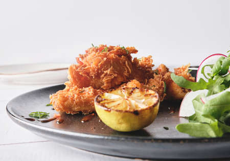 Crispy fried chicken with gourmet arugula and radish salad, accompanied by Peruvian chili sauces,...