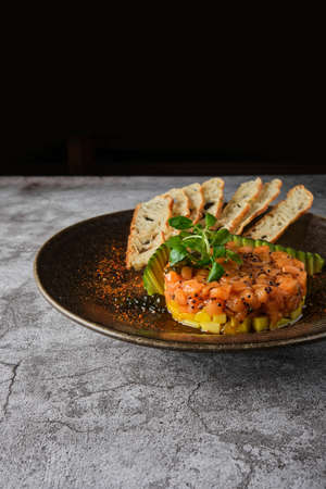Gourmet fish tartar raw from tuna fillet with hashed avocado, selective focusの写真素材