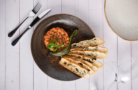 Gourmet fish tartar raw from tuna fillet with hashed avocado, selective focus