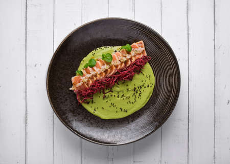 Close-up of savory Japanese salmon tataki dish topped with sesame and served with crispy strips. isolated on modern background. selective focusの写真素材