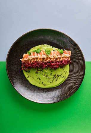 Close-up of savory Japanese salmon tataki dish topped with sesame and served with crispy strips. isolated on modern background. selective focusの写真素材