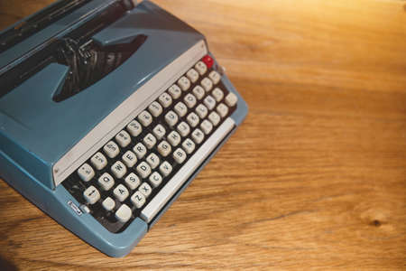 Retro old typewriter on blur background and front of wooden table. Vintage concept, selective Focus.の写真素材