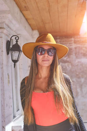 Beautiful smiling woman enjoying on vacation. Portrait of happy woman using hat. Shes got styleの写真素材