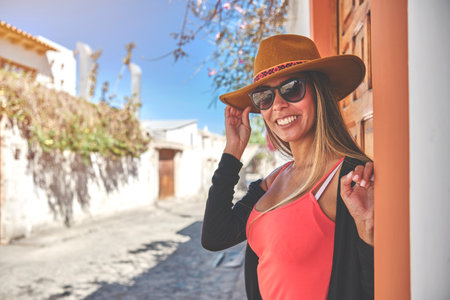 Beautiful smiling woman enjoying on vacation. Portrait of happy woman using hat. Shes got styleの写真素材