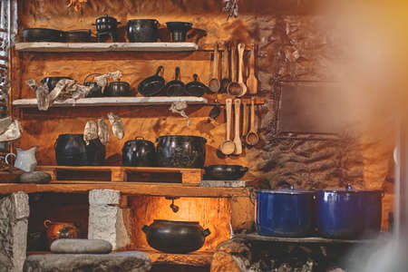 Cast iron pot with fresh herbs, spices and kitchen utensils for tasty cooking on rustic table. Homemade cooking. Dark.の写真素材