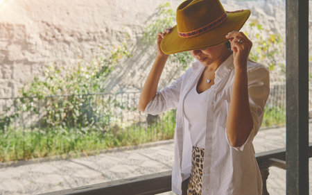 Woman wearing cowboy hat sitting on porch, Jalisco Mexico, Portrait of happy woman using hat. Selective Focus.の写真素材