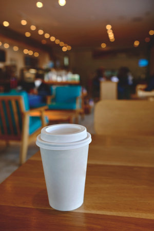 takeaway cup of coffee in coffee shop background, Selective focus. Mockup concept.の写真素材