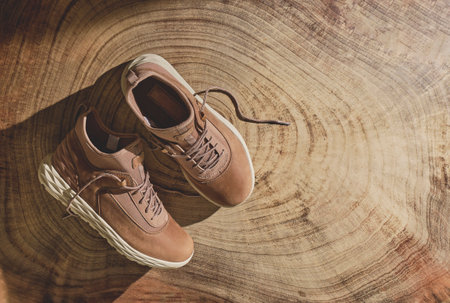 A pair of brown leather waterproof trekking boots on a wooden background. Hiking concept.の写真素材