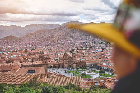 Tourist with woolen hat on San Cristobal viewpoint looking the main square of Cuzco. Peru