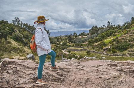 Beautiful tourist girl exploring Tambomachay Inca ruins near Cusco in Peru. Travel concept.の写真素材
