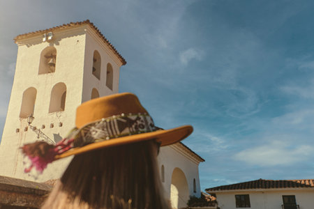 Young woman tourist in sunhat standing back in Chinchero. Peru.